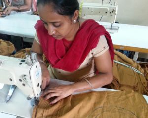 Mujer tejiendo en la organización de Comercio Justo Creative una prenda de algodón orgánico